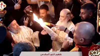 ظهور النور المقدس الآن من قبر المسيح وبطريرك القدس يخرج بالشعلة المضيئة من كنيسة القيامة 