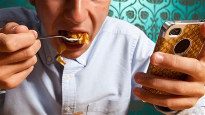 شوف جسمك بيحصله إيه لو بتستخدم الهاتف أثناء الأكل